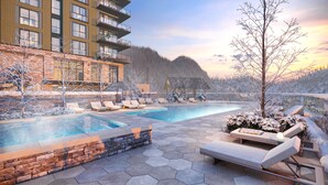 Un espace piscine avec des chaises longues, un mur en pierre et une vue sur une montagne.