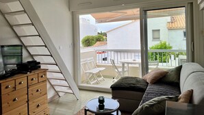 A room with a sliding glass door leading to an outdoor area with a table and chairs.