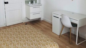 A bedroom with a bed, a desk, a chair, a wardrobe, and a hanging light fixture. - Apartment triple gare Angers (Angers)
