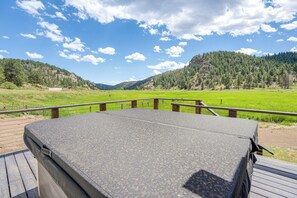 A hot tub on a wooden deck with a view of a green field and forested hills. - Creekside Florrisant Hideaway - Great for Anglers! (Florissant)