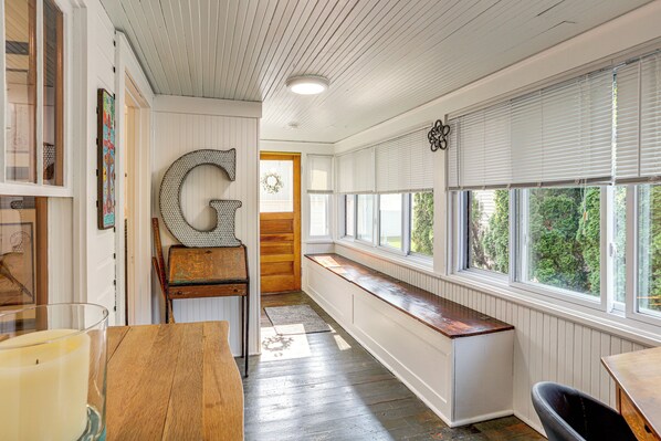 Una habitación con un banco de madera grande, un candelabro de cristal y una gran letra 'G' en la pared.