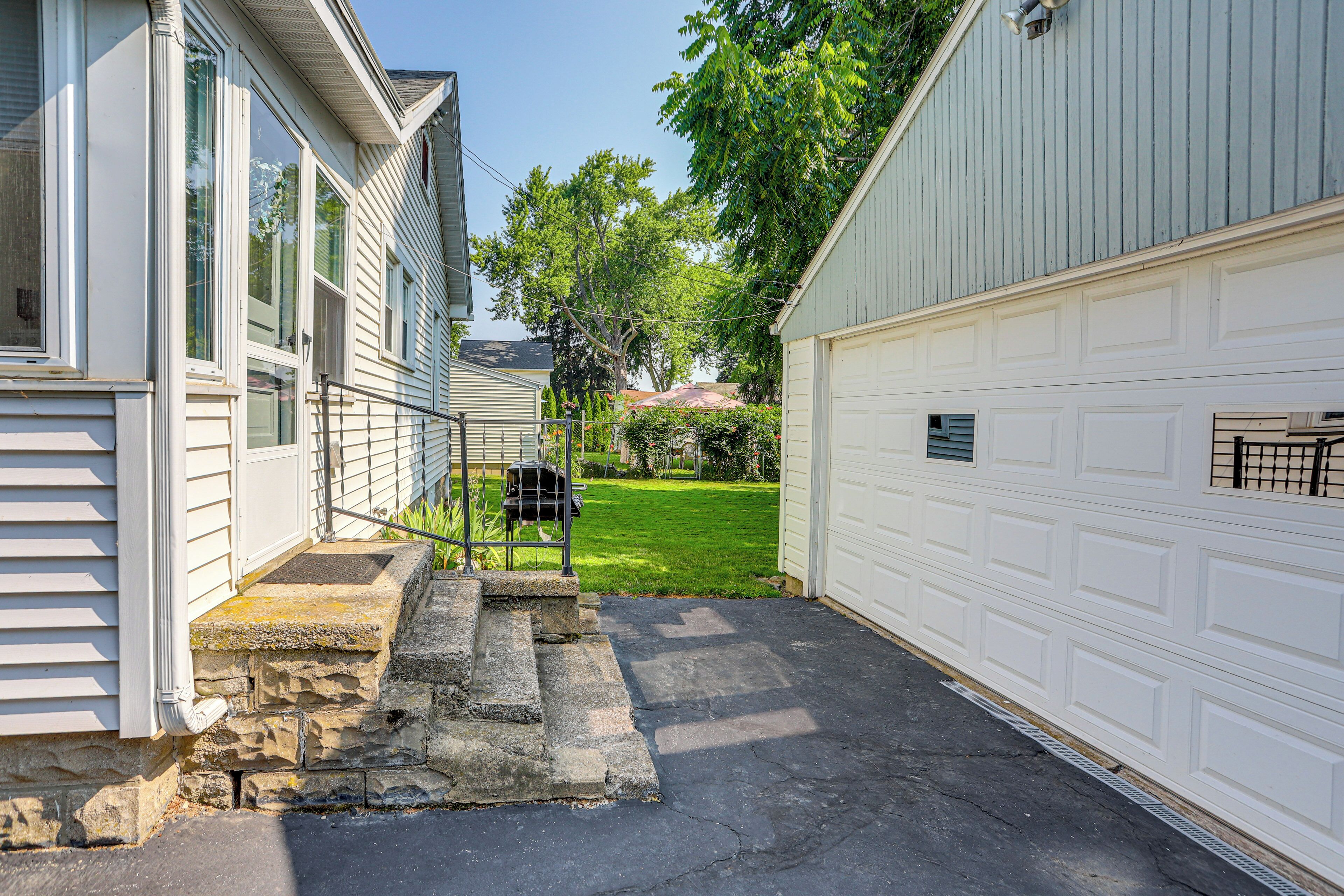 A residential garage with a stone staircase leading up to a front door.