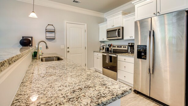 A kitchen with granite countertops, stainless steel appliances, white cabinetry, and a pendant light. - 1 Mi to Riverfront: Darien Family Home (Darien)