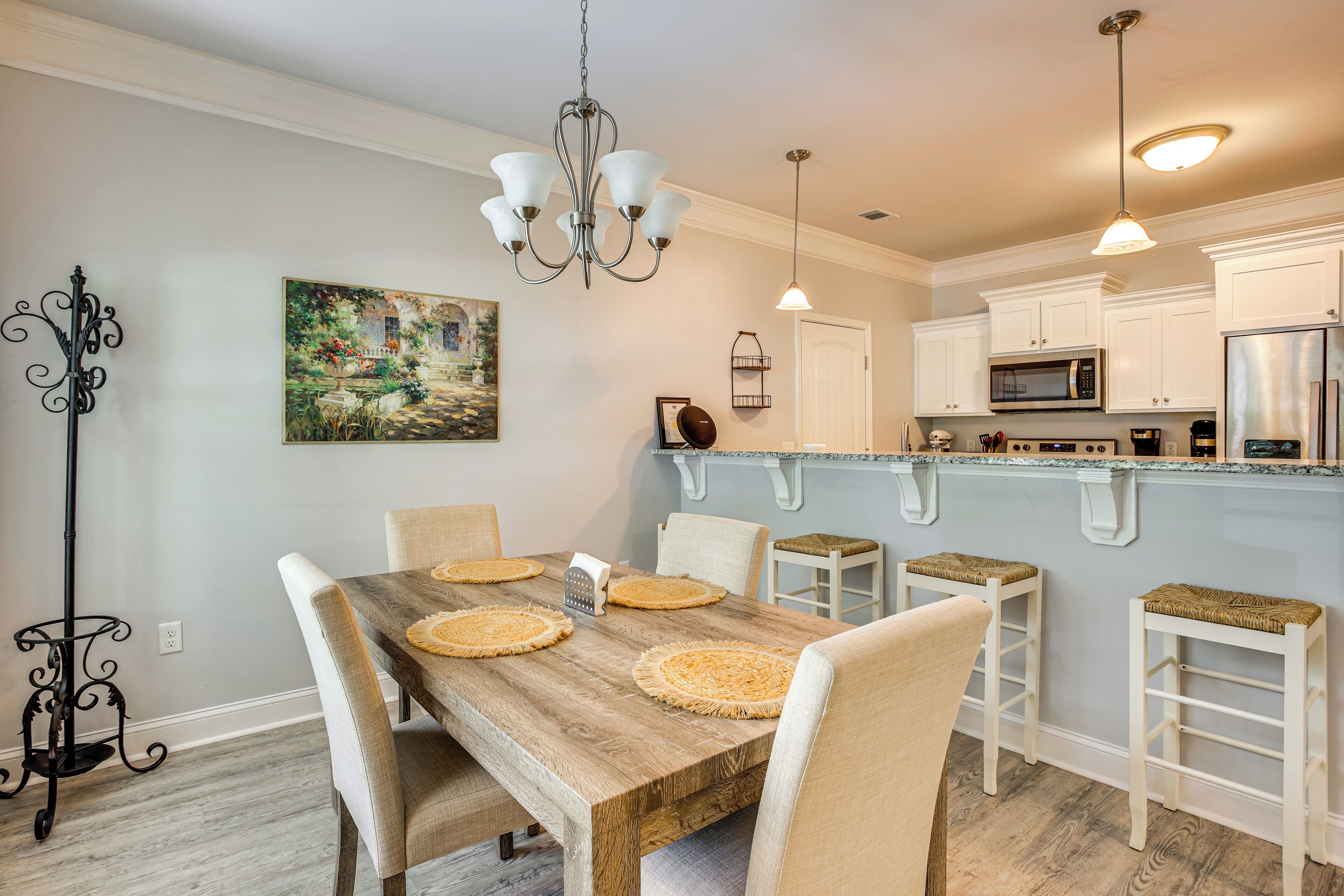 A dining area with a wooden table, white chairs, and woven placemats.