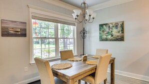 A dining room with a wooden table, four chairs, a chandelier, and artwork on the walls. - 1 Mi to Riverfront: Darien Family Home (Darien)