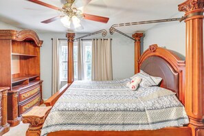 A bedroom with a large bed, wooden furniture, a ceiling fan, and a window with curtains. - Pool & Tennis Court Access: Home in Warner Robins (Warner Robins)