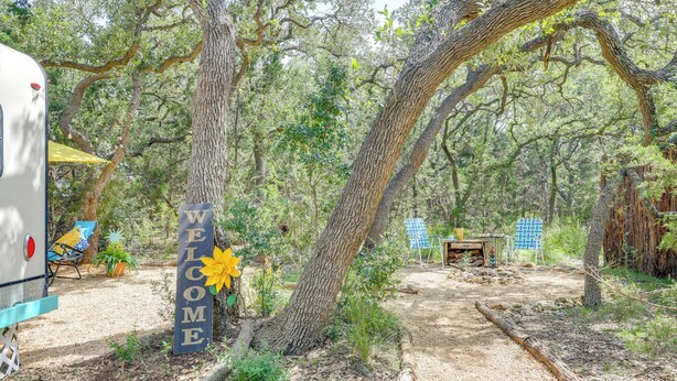 A campsite with a 'WELCOME' sign, a tent, and a dining table set up in a wooded area. - 6 Mi to Wimberley Square: 'Happy Days Cruiser' (Wimberley)