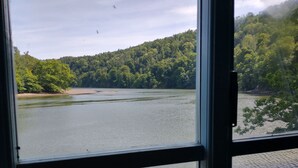 A view of a river with a forested hillside in the background. - The Sharpham Boat House (Totnes)