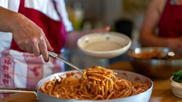 A person cooking spaghetti in a large pan.