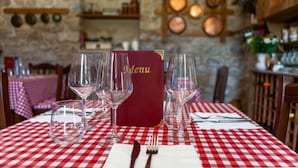A dining table with a red and white checkered tablecloth, a menu stand, and wine glasses. - IL POGGIO DEGLI ANTICHI SAPORI (Paternopoli)