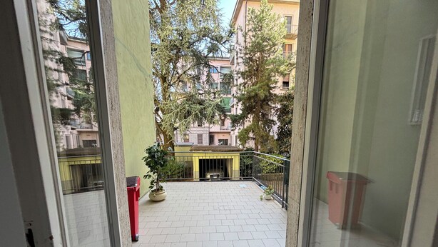 Une vue depuis un balcon doté d’un sol carrelé, de plantes en pot et d’une balustrade.