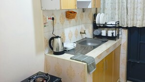 A compact kitchen with a gas stove, a kettle, and a sink. - one bedroom apartment in juja (Juja)