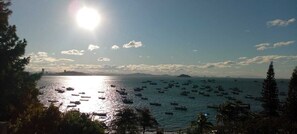 A coastal view with numerous boats on the water, a clear sky, and distant landforms. - Maricá Apart Hotel (Penha)