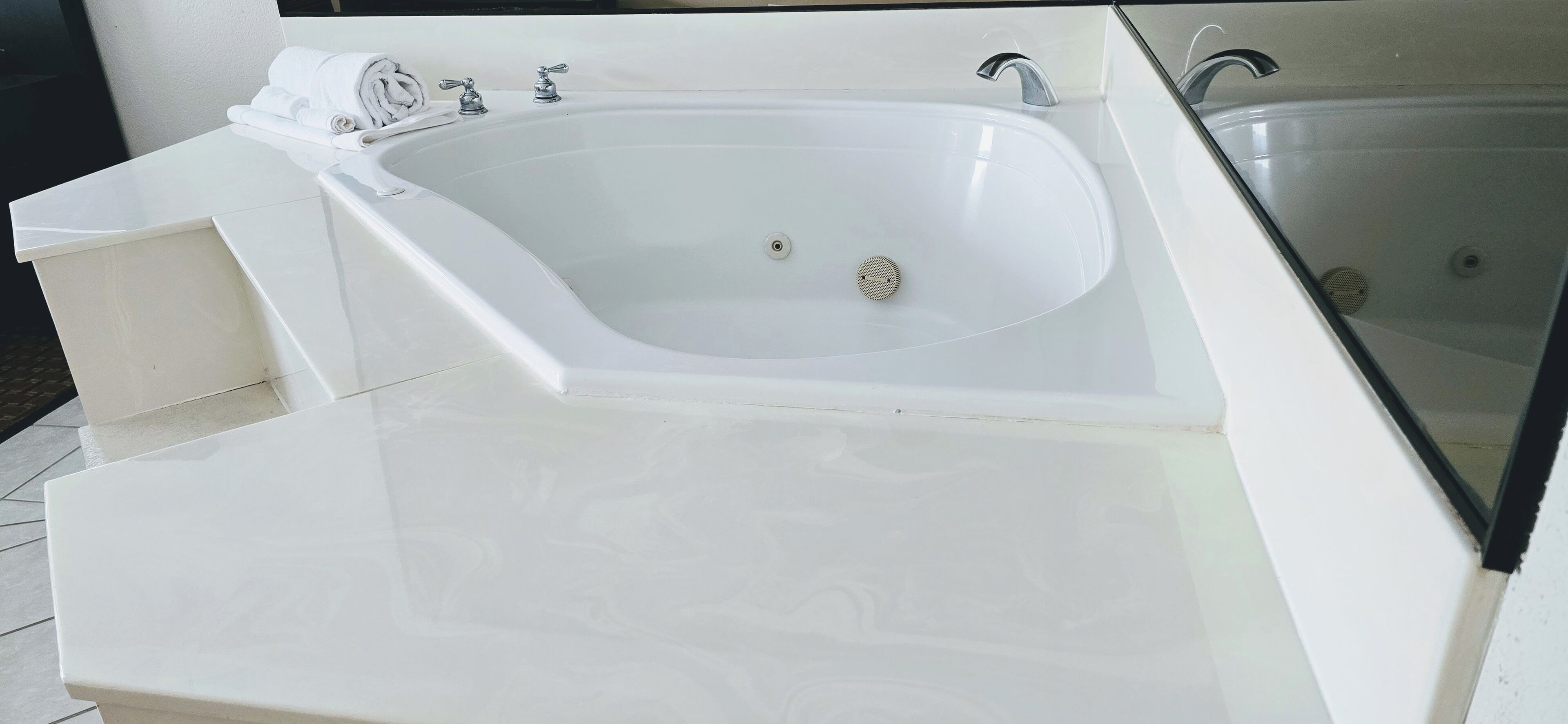 A modern bathroom with a large white bathtub, a separate shower area, and a vanity with a mirror.