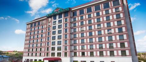 Un hotel de varios pisos con un letrero llamativo que dice "Grand Plaza Hotel".