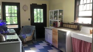 A kitchen with a stove, sink, and cabinets. There is a window with blinds, a rug, and a door. - 3-bedroom bungalow very near downtown and walking distance to VT (Blacksburg)