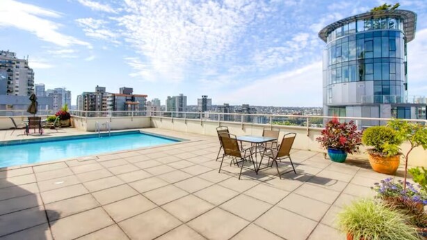 A rooftop terrace with a swimming pool, outdoor seating, and potted plants.