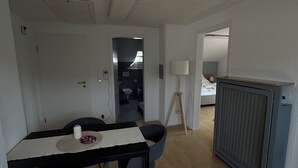 A modern dining area with a table, chairs, and a lamp.