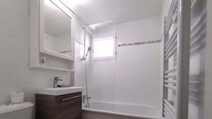 A bathroom with a toilet, sink, mirror, shower, and bathtub. - Small house Hourtin port (Hourtin)