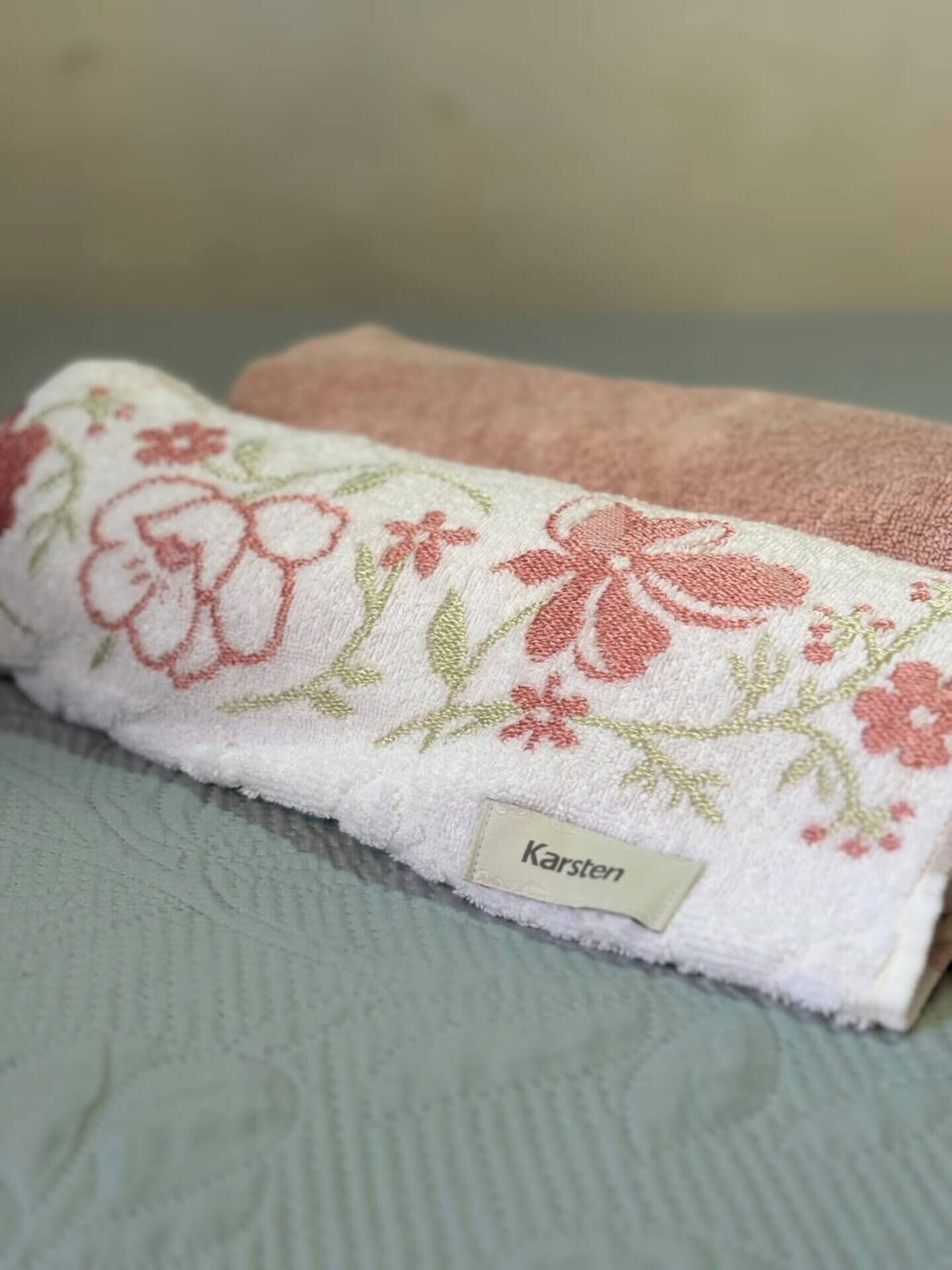 Una toalla doblada con estampado floral y la palabra 'Karsten' escrita en ella.