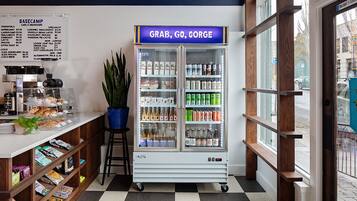 A cafe with a menu board, a beverage dispenser, and a variety of snacks and drinks.