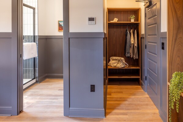 A hallway with a wooden floor, a grey wall, and a wooden door. - Lightwell Hotel & Spa (Hood River)
