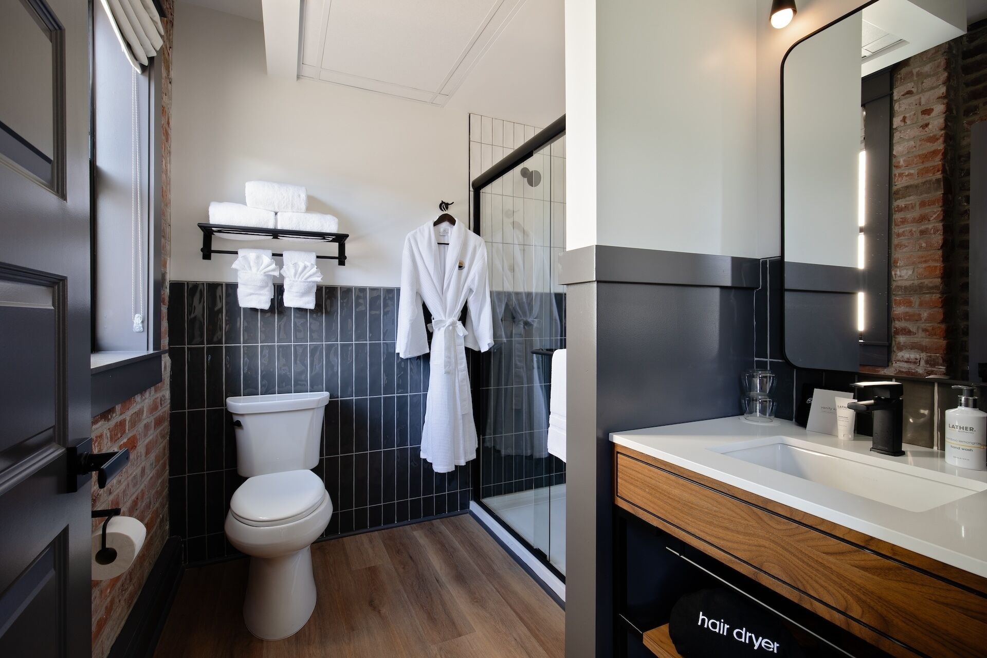A modern bathroom with a toilet, a shower area, and a vanity with a mirror.
