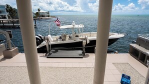 A boat docked at a marina with a view of the ocean and a clear sky.