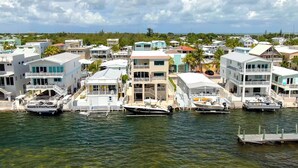 A marina with multiple boats docked, surrounded by residential buildings with balconies and waterfront views.
