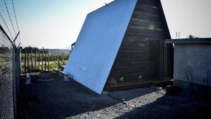 Een gebouw met een schuin dak en een hek van gaas.