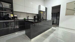 Een moderne keuken met een zwart aanrecht, witte kasten en roestvrijstalen apparatuur.