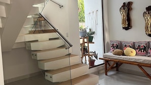 A modern staircase with glass railings and wooden steps leading to an upper level. - ECORIVERA RESORT FARM (Rivera)