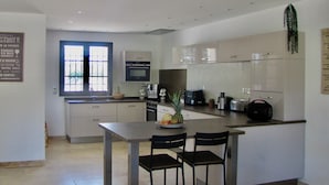 Una cocina moderna con una isla central, microondas, cafetera y tostadora.