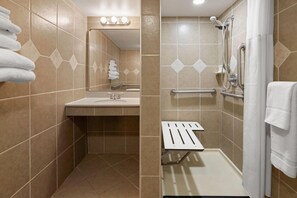 A bathroom with a sink, mirror, towel rack, shower with grab bars, and a toilet. - Tesla Biohealing Wellness Hotel & Resort, Ramada by Wyndham (Butler)