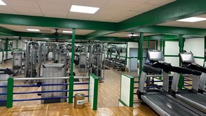 A gym with various exercise equipment, including treadmills and weight machines. - Tesla Biohealing Wellness Hotel & Resort, Ramada by Wyndham (Butler)