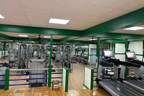A gym with various exercise equipment, including treadmills and weight machines. - Tesla Biohealing Wellness Hotel & Resort, Ramada by Wyndham (Butler)