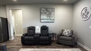 A living room with a gray sofa, a recliner, a small table, and a rug. - Silver Leaf (Stillwater)