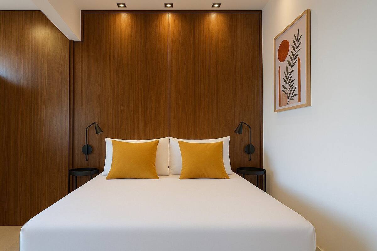 Ein Schlafzimmer mit einem großen Bett, zwei Nachttischlampen und einem gerahmten Kunstwerk an der Wand.