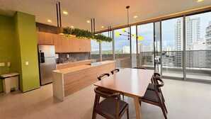 Una cocina moderna con comedor, ventanas amplias y vista a la ciudad.