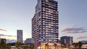 Un hotel moderno de gran altura con múltiples pisos y un llamativo letrero que dice 'ON'.