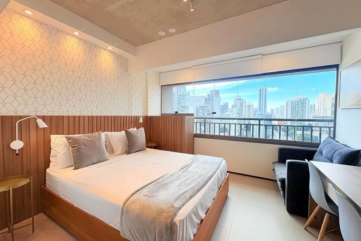 Ein modernes Schlafzimmer mit Blick auf die Stadt, ein Bett, ein Schreibtisch und ein Stuhl.
