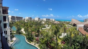 Un complexe hôtelier doté d’une piscine, de palmiers et offrant une vue sur l’océan.
