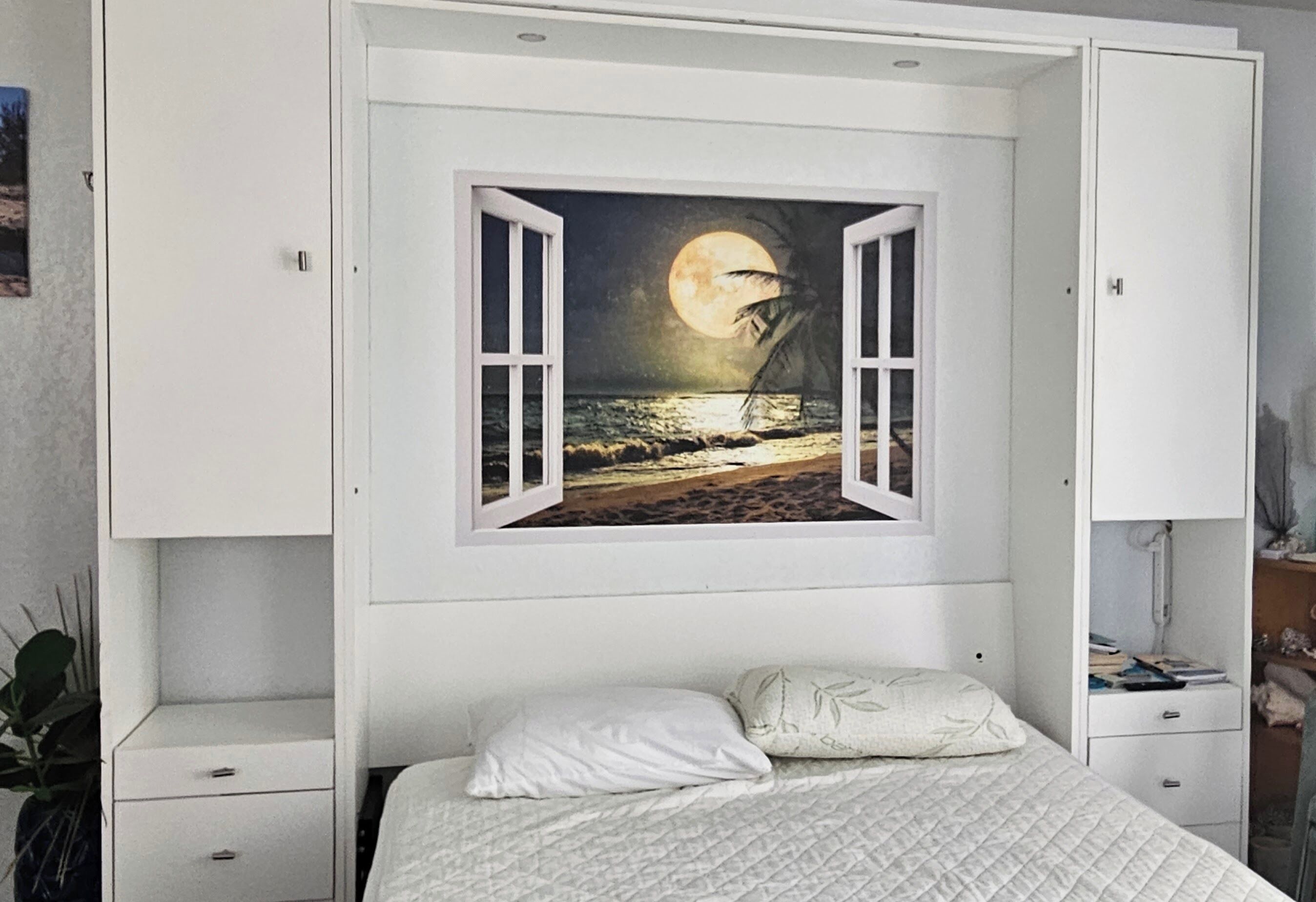 Un dormitorio con una cama, un cuadro de noche estrellada y un armario blanco.