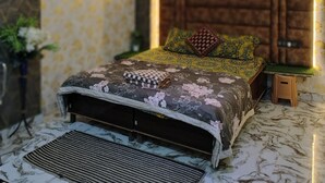 Una camera da letto con un letto, un comodino, una mensola a parete e una ventola a soffitto.