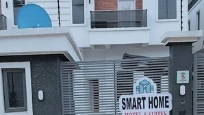 A two-story building with a sign reading "SMART HOME HOTEL & SUITES". - Smart Home Hotel Lagos (Lekki)
