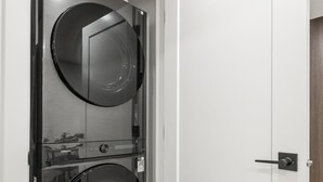 A modern door with a built-in washer and dryer unit. - Lake Community Hideout (Chestermere)