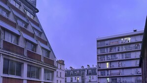 A multi-story residential building with a modern design, featuring balconies and large windows.