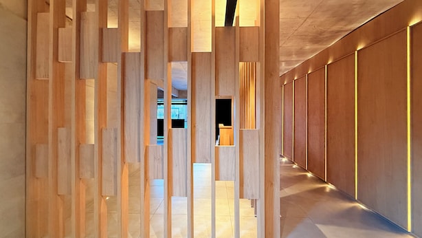 Un pasillo con listones de madera e iluminación empotrada.