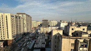 A cityscape with high-rise buildings, a parking lot, and a construction site.