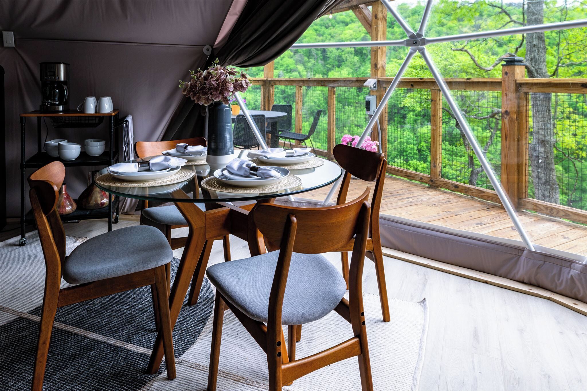 A dining area with a round table, chairs, and a coffee station.